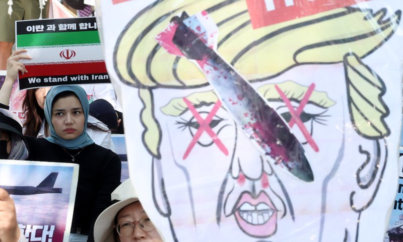 [서울=뉴시스] 추상철 기자 = 트럼프 미국 대통령이 이란의 주요 핵 시설을 파괴했다고 밝힌 22일 오후 서울 종로구 교보빌딩 인근에서 열린 노동자연대의 '전쟁 중단 및 이스라엘 공격 규탄집회'에서 이란인 등 집회 참가자가 피켓을 들고 전쟁 중단을 촉구하고 있다. 2025.06.22. scchoo@newsis.com