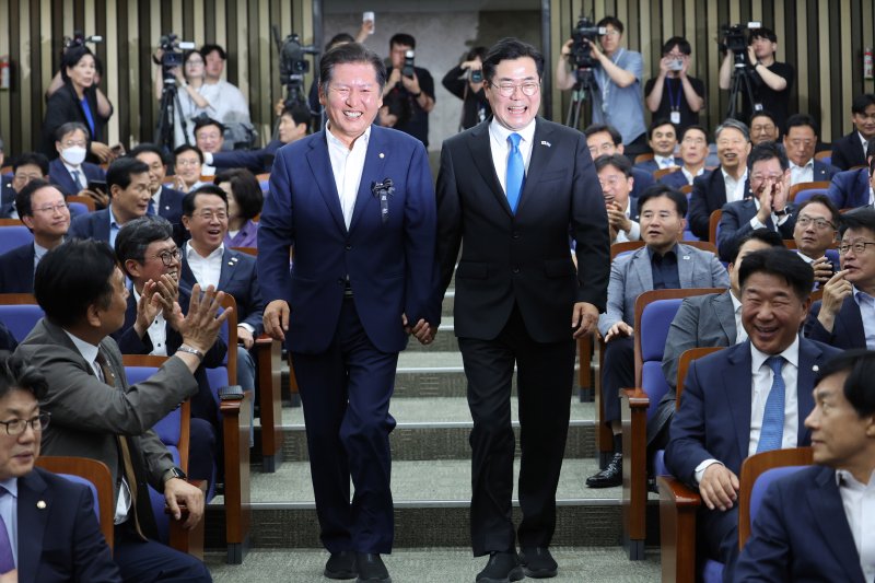 [서울=뉴시스] 김명년 기자 = 더불어민주당 당대표 출마 선언을 한 정청래(왼쪽), 박찬대 의원이 24일 오후 서울 여의도 국회에서 열린 의원총회에서 손을 잡고 입장하고 있다. 2025.06.24. kmn@newsis.com