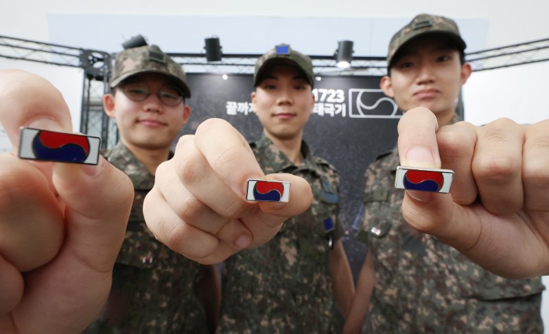 [서울=뉴시스] 김진아 기자 = 25일 서울 용산구 서울역 대합실에서 진행된 보훈부와 한화, 6·25전쟁 75주년 기념 '121723 끝까지 찾아야 할 태극기' 캠페인에서 군 장병들이 태극기 배지를 선보이고 있다. 보훈부는 6·25전쟁 75주년 계기 한화의 K9 자주포 철로 지금까지 돌아오지 못한 국군 전사자 121,723명의 호국영웅을 상징하는 12만 1,723개의 고유번호가 부여된 태극기 배지를 제작, 무료 배포했다. 2025.06.25. bluesoda@newsis.com