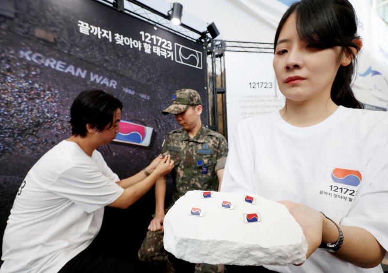 [서울=뉴시스] 김진아 기자 = 25일 서울 용산구 서울역 대합실에서 진행된 보훈부와 한화, 6·25전쟁 75주년 기념 '121723 끝까지 찾아야 할 태극기' 캠페인에서 군 장병들이 태극기 배지를 달고 있다. 보훈부는 6·25전쟁 75주년 계기 한화의 K9 자주포 철로 지금까지 돌아오지 못한 국군 전사자 121,723명의 호국영웅을 상징하는 12만 1,723개의 고유번호가 부여된 태극기 배지를 제작, 무료 배포했다. 2025.06.25. bluesoda@newsis.com