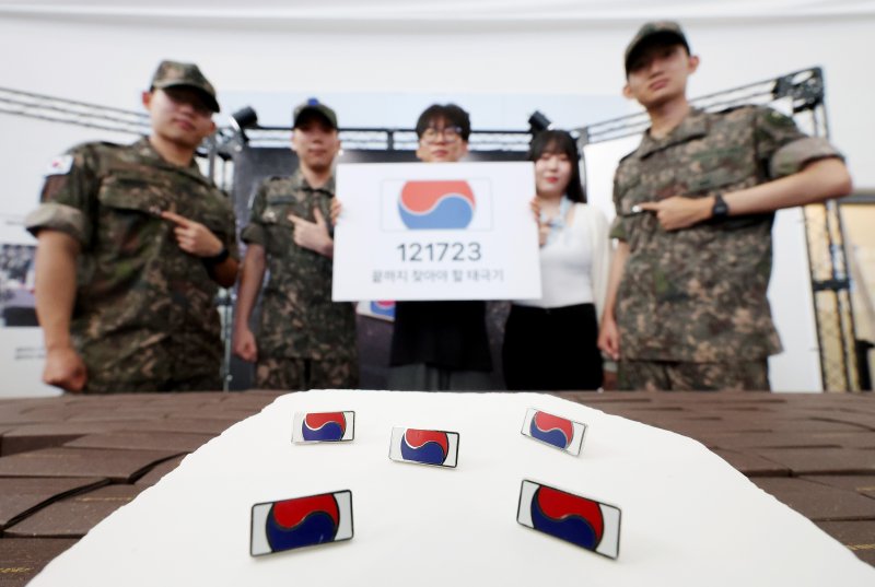 [서울=뉴시스] 김진아 기자 = 25일 서울 용산구 서울역 대합실에서 진행된 보훈부와 한화, 6·25전쟁 75주년 기념 '121723 끝까지 찾아야 할 태극기' 캠페인에서 군 장병들이 태극기 배지를 선보이고 있다. 보훈부는 6·25전쟁 75주년 계기 한화의 K9 자주포 철로 지금까지 돌아오지 못한 국군 전사자 121,723명의 호국영웅을 상징하는 12만 1,723개의 고유번호가 부여된 태극기 배지를 제작, 무료 배포했다. 2025.06.25. bluesoda@newsis.com
