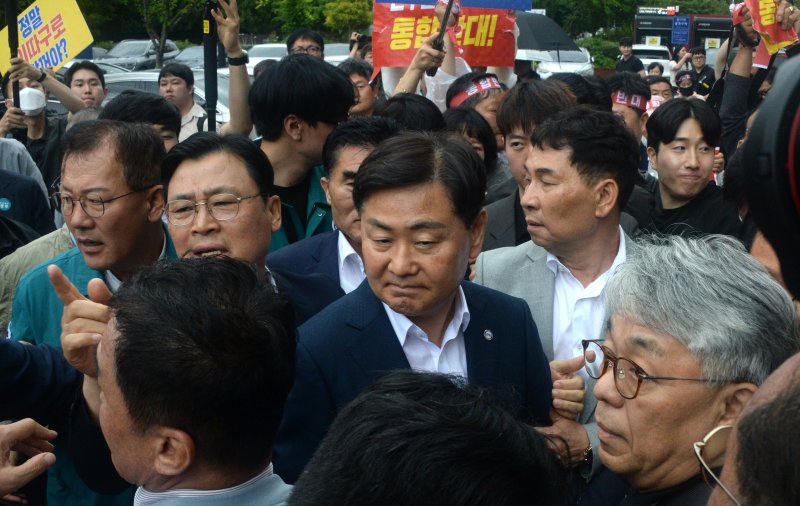 [완주=뉴시스] 김얼 기자 = 완주군민과의 대화를 위해 완주군청을 찾은 김관영(가운데) 전북특별자치도지사가 25일 전북 완주군청에서 대화를 거부하는 완주-전주 통합반대 완주군민대책위원회의 거센 항의에 장내를 빠져나오고 있다. 2025.06.25. pmkeul@newsis.com