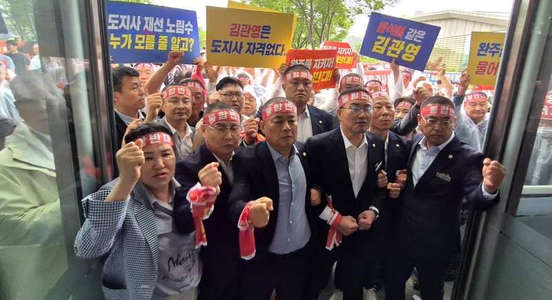 [완주=뉴시스] 김얼 기자 = 완주-전주 통합을 반대하는 완주군의회 의원들이 25일 전북 완주군 완주군청 입구에서 군민과의 대화를 위해 찾은 김관영 전북특별자치도지사의 완주군청 방문을 거부하며 농성을 펼치고 있다. 2025.06.25. pmkeul@newsis.com