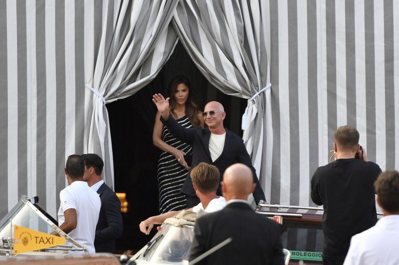 [베네치아=AP/뉴시스] 아마존 창업자 제프 베이조스(오른쪽)와 약혼녀 로런 산체스가 25일(현지 시간) 이탈리아 베네치아의 한 호텔에서 나오고 있다. 베이조스가 베네치아에서 초호화 결혼식을 계획했지만, 혼잡을 우려한 현지 시민들의 거센 반발에 장소 변경을 검토 중인 것으로 알려졌다. 두 사람은 26일부터 28일까지 사흘간 베네치아에서 결혼식을 올릴 예정이었다. 2025.06.26.