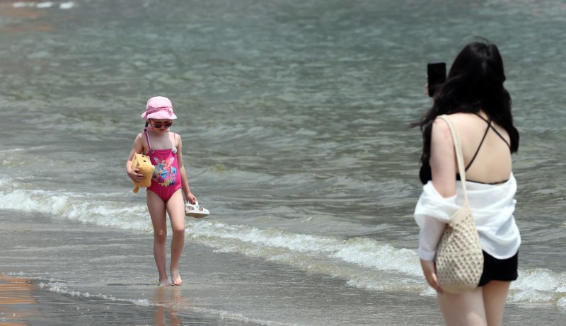 [부산=뉴시스] 하경민 기자 = 부산지역에 올해 첫 폭염특보가 발효된 27일 부산 수영구 광안리해수욕장에서 시민과 관광객들이 물놀이를 즐기고 있다. 2025.06.27. yulnetphoto@newsis.com