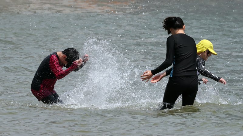 [부산=뉴시스] 하경민 기자 = 부산지역에 올해 첫 폭염특보가 발효된 27일 부산 수영구 광안리해수욕장에서 시민과 관광객들이 물놀이를 즐기고 있다. 2025.06.27. yulnetphoto@newsis.com