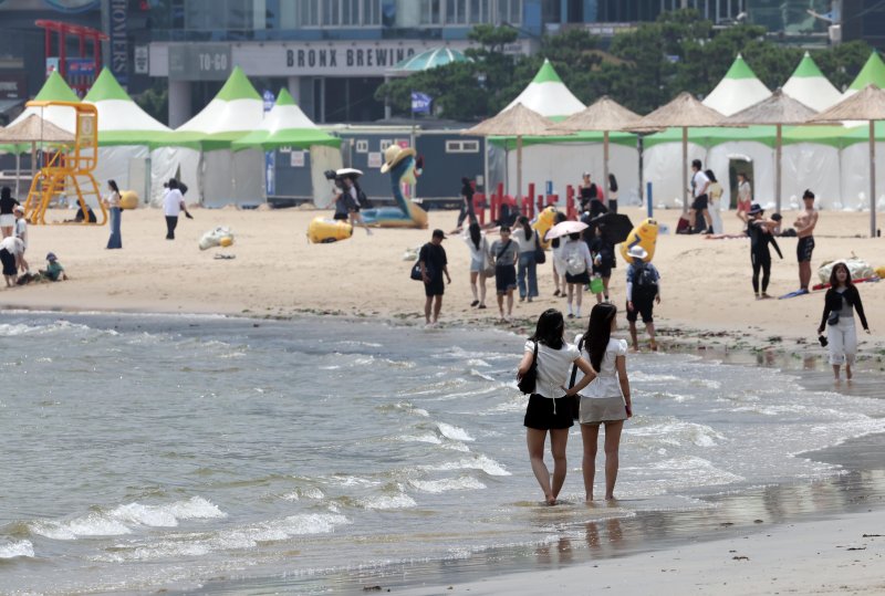 [부산=뉴시스] 하경민 기자 = 부산지역에 올해 첫 폭염특보가 발효된 27일 부산 수영구 광안리해수욕장에서 시민과 관광객들이 물놀이를 즐기고 있다. 2025.06.27. yulnetphoto@newsis.com