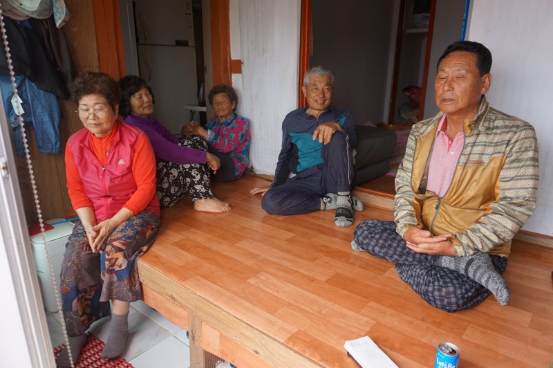 '주민의 절반'…김창환 이장(오른쪽)과 주민들이 '높은자리' 김용희 씨 집에 한데 모여 담소를 나누고 있다.2025.6.27/뉴스1 ⓒ News1 조영석 기자