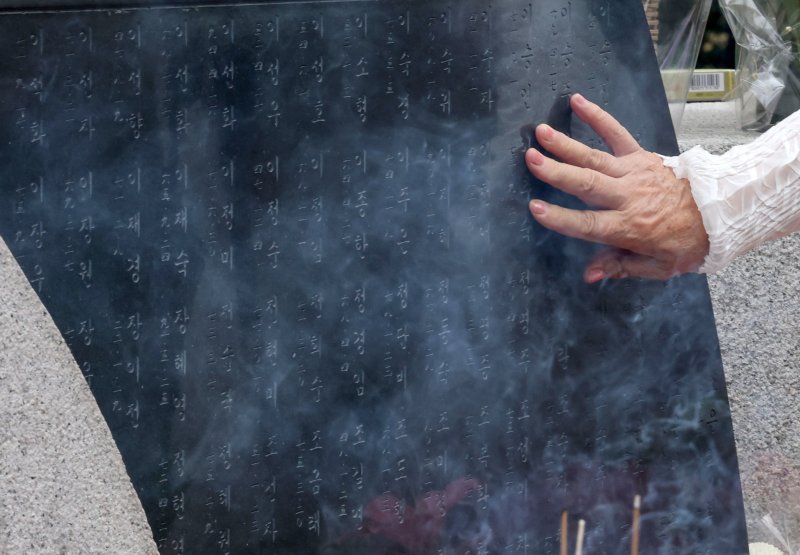 29일 서울 서초구 매헌시민의숲 삼풍참사위령탑에서 열린 삼풍백화점 붕괴 참사 30주기 추모식에서 한 유가족이 위령탑의 희생자 이름을 어루만지고 있다. 2025.6.29/뉴스1 ⓒ News1 박세연 기자