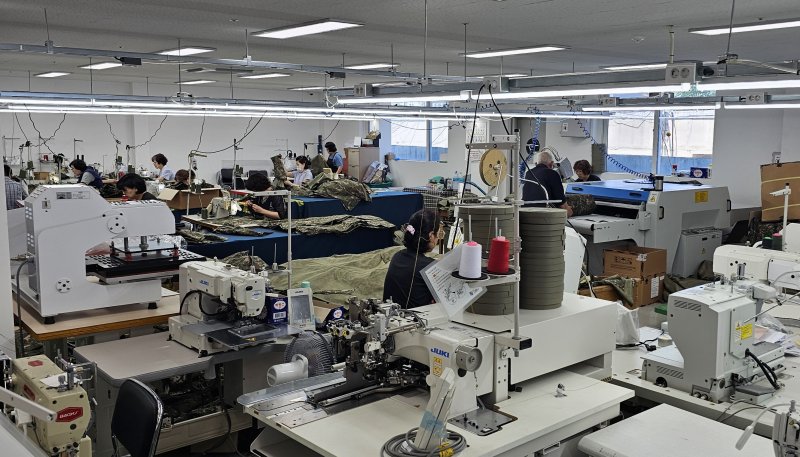 지난 27일 찾은 부산서동의류제조지원센터 현장. 1층 스마트제조 시범공장에서 종사자들이 국방부에 납품할 군용우의를 만들고 있다. 사진=변옥환 기자