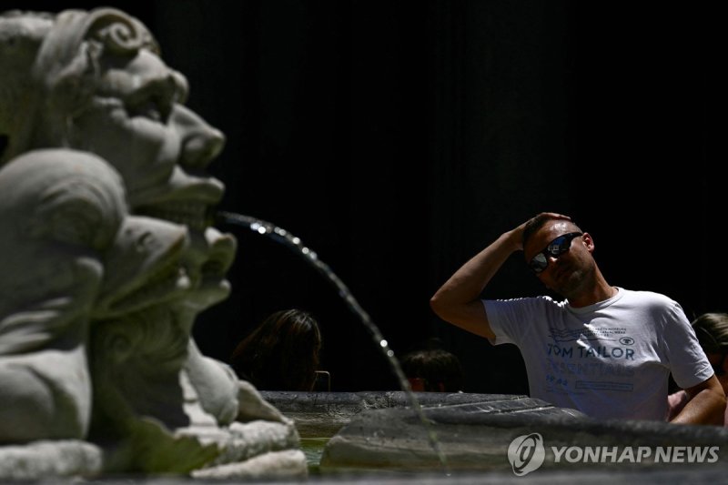 이탈리아 로마의 한 분수대에서 물로 머리를 식히는 관광객 (출처=연합뉴스)