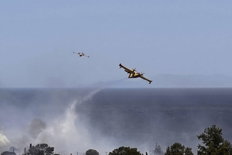 [AP/뉴시스] 26일 그리스 아테네 남부 팔라이아 포카이야 해변에서 소방 헬리가 물을 뿌리고 있다