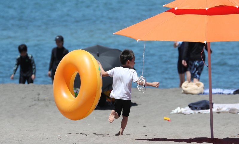 [제주=뉴시스] 우장호 기자 = 제주 북부지역에 올해 첫 폭염특보가 내려진 29일 제주시 이호테우해수욕장에서 튜브를 든 아이가 바다를 향해 달려가고 있다.기상청에 따르면 당분간 폭염특보가 발표된 제주도북부, 동부, 중산간을 중심으로 뜨겁고 습한 남풍류가 유입돼 무더운 날씨가 이어질 것으로 전망된다. 2025.06.29. woo1223@newsis.com