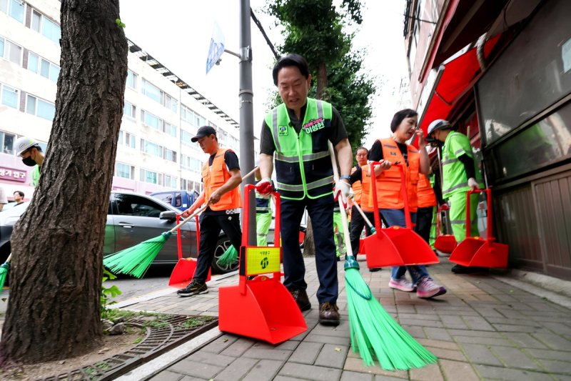 거리 청소하는 이성헌 구청장 (출처=연합뉴스)