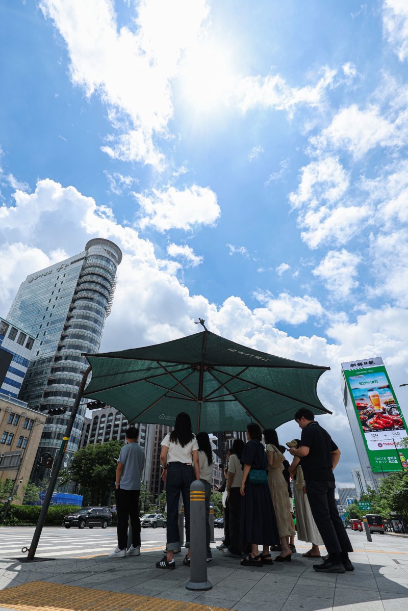 [서울=뉴시스] 권창회 기자 = 서울지역에 이틀째 폭염주의보가 지속중인 1일 서울 종로구 광화문광장 인근에서 시민들이 더위를 피해 그늘에서 신호대기를 하고 있다. 2025.07.01. kch0523@newsis.com