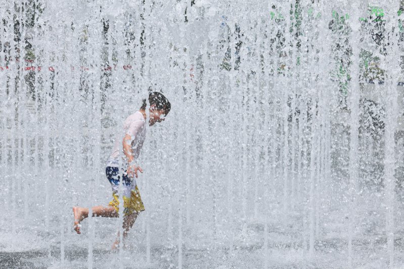 [서울=뉴시스] 권창회 기자 = 서울지역에 이틀째 폭염주의보가 지속중인 1일 서울 종로구 광화문광장 인근에서 외국인 관광객이 물놀이를 하고 있다. 2025.07.01. kch0523@newsis.com