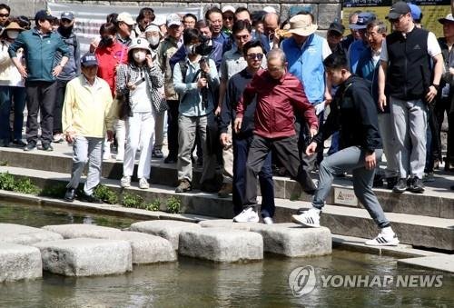 청계천 징검다리 폴짝폴짝 넘는 이명박 (출처=연합뉴스)
