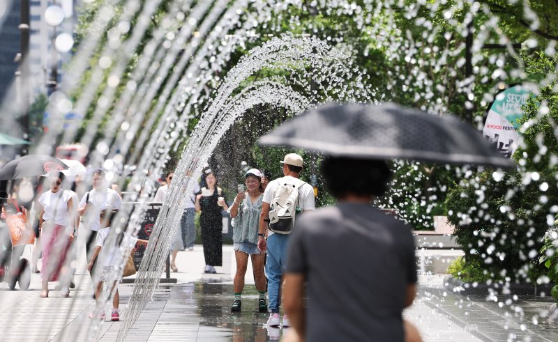 고온다습한 찜통더위가 이어진 1일 오후 서울 종로구 광화문 광장을 찾은 관광객이 바닥분수에서 더위를 식히고 있다. 2025.7.1/뉴스1 ⓒ News1 장수영 기자