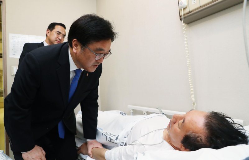 [서울=뉴시스] 우원식 당시 더불어민주당 원내대표가 10일 오후 '드루킹 특검'을 요구하며 8일째 단식농성 중 건강악화로 서울 여의도 한 병원 응급센테로 이송된 김성태 당시 자유한국당 원내대표를 방문해 대화를 나누고 있다. (사진=홍효식 기자) 2018.05.10.