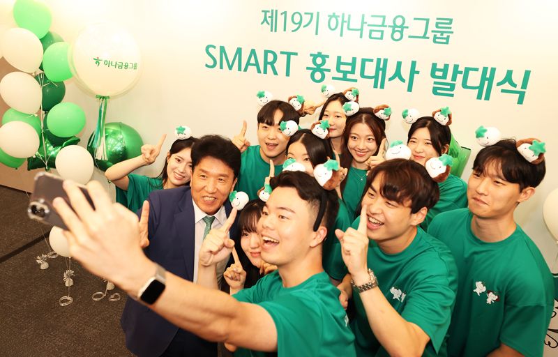 하나금융그룹은 지난 1일 서울 중구 하나금융 명동사옥 대강당에서 '제19기 스마트(SMART) 홍보대사' 발대식을 갖고, 새롭게 선발된 스마트 홍보대사 50명의 공식 활동을 시작했다. 발대식에 참석한 함영주 하나금융그룹 회장(왼쪽 두번째)이 스마트 홍보대사들과 함께 ‘하나’를 의미하는 손가락 포즈를 취하며 기념촬영을 하고 있다. 하나금융 제공