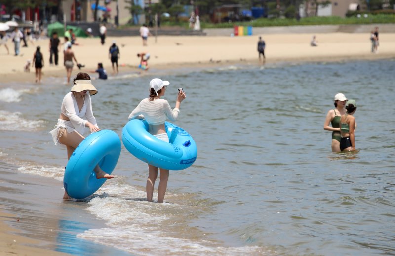 무더위가 기승을 부린 1일 개장한 부산 수영구 광안리해수욕장을 찾은 관광객들이 물놀이를 즐기며 더위를 식히고 있다. 부산 7개 해수욕장 중 해운대·송정해수욕장은 지난달 21일 개장했으며, 광안리·송도·다대포·일광·임랑해수욕장 등 5개 해수욕장은 이날 문을 열었다. ⓒ News1 윤일지 기자