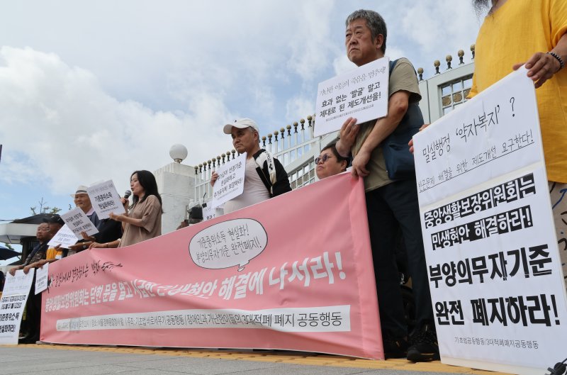 [서울=뉴시스] 김명원 기자 = 기초법바로세우기 공동행동 등 참석자들이 지난해 7월 25일 오전 서울 종로구 정부서울청사 앞에서 정부 중앙생활보장위원회에 기준중위소득 현실화와 부양의무자기준 완전 폐지를 요구하는 민중생활보장위원회 기자회견을 하고 있다. 2024.07.25. kmx1105@newsis.com