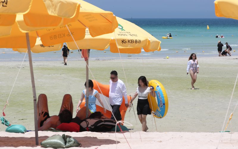[제주=뉴시스] 우장호 기자 = 무더위가 기승을 부린 3일 오후 제주시 한림읍 협재해수욕장을 찾은 피서객들이 바닷물에 발을 담그며 더위를 식히고 있다. 기상청은 이날 제주 지역 장마가 사실상 지난달 26일 종료됐다고 발표했다. 올해 제주 장마 기간은 지난달 12~26일로 2주간이었으며, 이는 기상 관측 사상 가장 일찍 종료된 장마로 기록됐다. 2025.07.03. woo1223@newsis.com