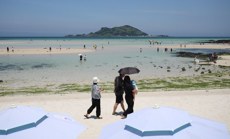 [제주=뉴시스] 우장호 기자 = 무더위가 기승을 부린 3일 오후 제주시 한림읍 협재해수욕장을 찾은 피서객들이 바닷물에 발을 담그며 더위를 식히고 있다. 기상청은 이날 제주 지역 장마가 사실상 지난달 26일 종료됐다고 발표했다. 올해 제주 장마 기간은 지난달 12~26일로 2주간이었으며, 이는 기상 관측 사상 가장 일찍 종료된 장마로 기록됐다. 2025.07.03. woo1223@newsis.com