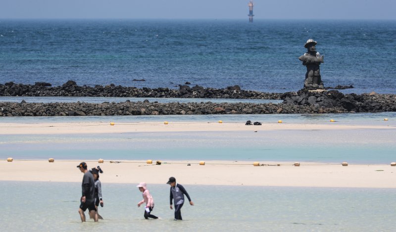 [제주=뉴시스] 우장호 기자 = 무더위가 기승을 부린 3일 오후 제주시 한림읍 금능해수욕장을 찾은 피서객들이 바닷물에 발을 담그며 더위를 식히고 있다. 기상청은 이날 제주 지역 장마가 사실상 지난달 26일 종료됐다고 발표했다. 올해 제주 장마 기간은 지난달 12~26일로 2주간이었으며, 이는 기상 관측 사상 가장 일찍 종료된 장마로 기록됐다. 2025.07.03. woo1223@newsis.com