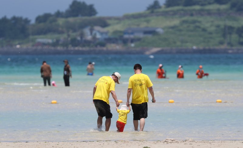 [제주=뉴시스] 우장호 기자 = 무더위가 기승을 부린 3일 오후 제주시 한림읍 금능해수욕장을 찾은 피서객들이 바닷물에 발을 담그며 더위를 식히고 있다. 기상청은 이날 제주 지역 장마가 사실상 지난달 26일 종료됐다고 발표했다. 올해 제주 장마 기간은 지난달 12~26일로 2주간이었으며, 이는 기상 관측 사상 가장 일찍 종료된 장마로 기록됐다. 2025.07.03. woo1223@newsis.com