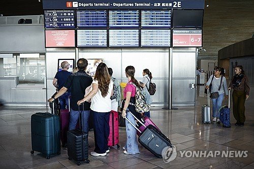 3일(현지시간) 파리 샤를 드골 공항에서 항공편 스케줄 안내판 바라보는 승객들 (출처=연합뉴스)