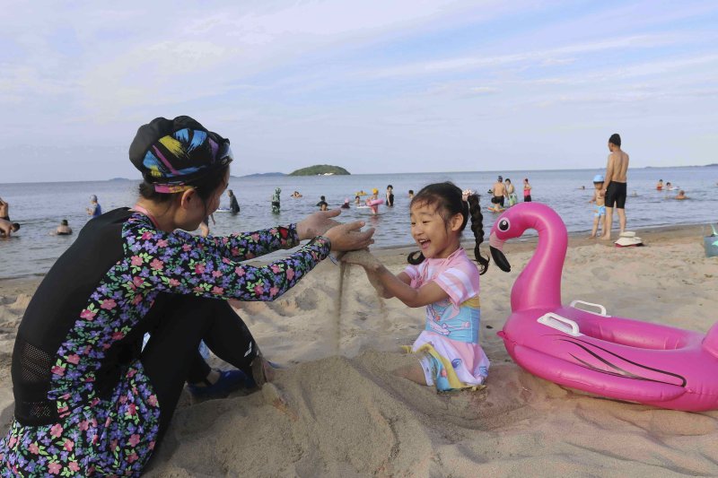 [원산=AP/뉴시스] 지난 1일 북한 강원도 원산의 원산-갈마 해안관광지구 해변에서 한 모녀가 모래 놀이를 하고 있다. 북한 노동신문은 갈마관광지구 개장을 알리며 "세상에 없는 황홀한 관광 명소"라고 선전했다. 원산 명사십리 해변 일대에 조성된 관광지구 개발은 북한이 11년간 공들인 숙원사업으로 알려져 있다. 2025.07.04.