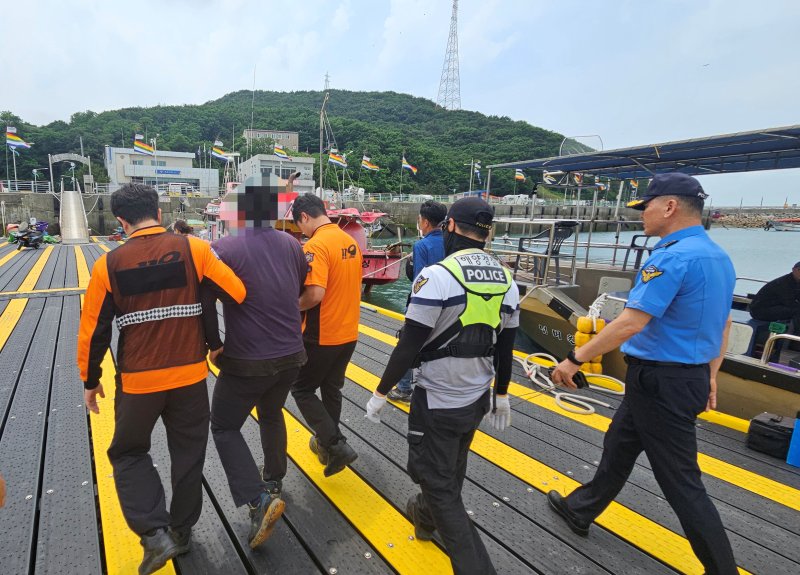 [서산=뉴시스] 평택해경이 4일 서산 대산 삼길포항에서 급유선 홋줄 보강 작업 중 부상을 입은 B씨를 119구급대에 인계하고 있다. (사진=평택해양경찰서 제공) 2025.07.04. photo@newsis.com *재판매 및 DB 금지