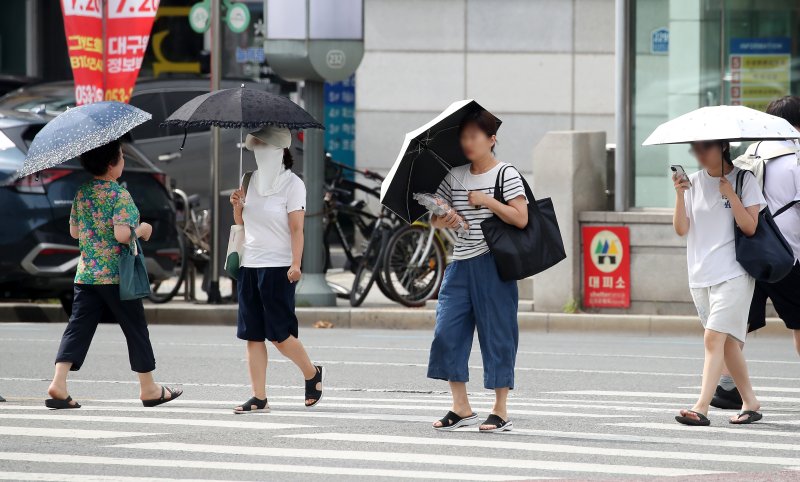 폭염이 일주일 넘게 이어진 4일 오후 대구 수성구 달구벌대로에서 시민들이 양산을 펼쳐 뙤약볕을 피하고 있다. (사진은 기사 내용과 무관함) 2025.7.4/뉴스1 ⓒ News1 공정식 기자