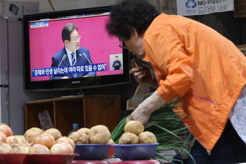 [서울=뉴시스] 황준선 기자 = 이재명 정부 첫 추가경정예산(추경)안이 총 31조8000억원 규모로 4일 확정됐다. 국회에 제출됐던 정부안(30조5000억원)보다 1조3000억원 순증한 규모다. 사진은 지난달 26일 오전 서울 서대문구 인왕시장의 상점 TV에 이재명 대통령의 2025년도 제2회 추가경정예산안 시정연설이 방송되고 있는 모습. 2025.06.26. hwang@newsis.com