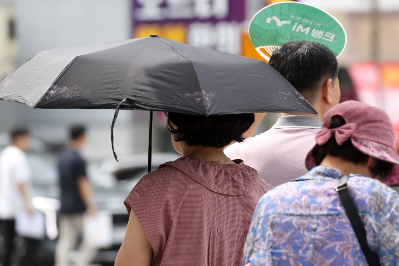 폭염이 일주일 넘게 이어진 4일 오후 뉴헤븐카지노 수성구 달구벌대로에서 시민들이 양산과 부채로 뙤약볕을 가리고 있다. 2025.7.4/뉴스1 ⓒ News1 공정식 기자