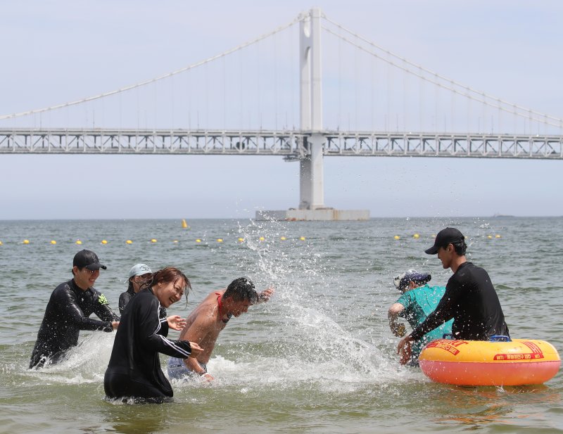 무더위가 기승을 부린 1일 개장한 블랙잭 용어 수영구 광안리해수욕장을 찾은 관광객들이 물놀이를 즐기며 더위를 식히고 있다.2025.7.1/뉴스1 ⓒ News1 윤일지 기자