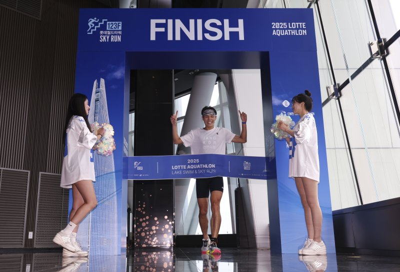 6일 오전 서울 송파구 잠실 롯데월드타워에서 열린 2025 롯데 아쿠아슬론에서 한 참가자가 결승점을 통과하고 있다. (공동취재) 2025.7.6/뉴스1 ⓒ News1 김성진 기자