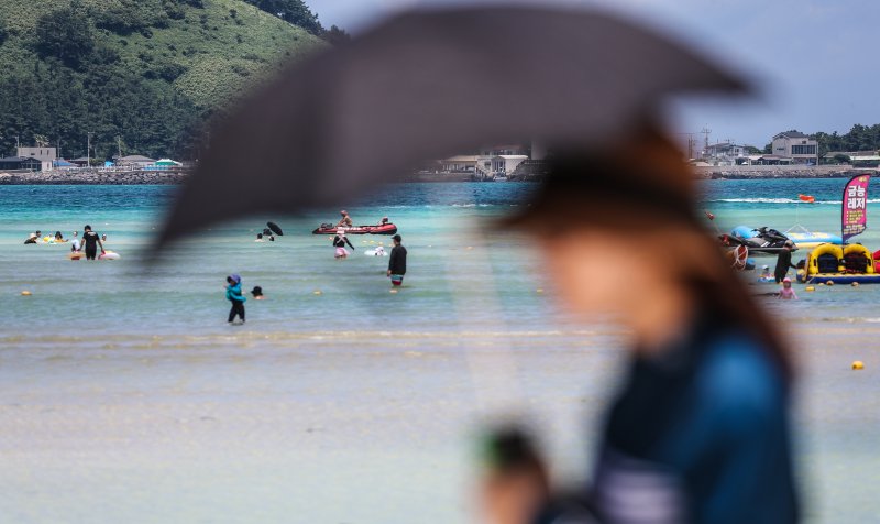 [제주=뉴시스] 우장호 기자 = 폭염의 기세가 수그러들지 않는 6일 오후 제주시 한림읍 금능해수욕장을 찾은 피서객들이 시원한 바닷물에 발을 담그며 더위를 식히고 있다. 2025.07.06. woo1223@newsis.com