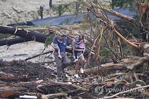 폭우 잔해 위로 걸어가는 텍사스 주민들 (출처=연합뉴스)