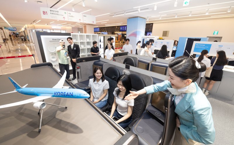 대한항공이 5일 서울 강남구 스타필드 코엑스몰에 문을 연 신규 기업이미지(CI) 콘셉트를 적용한 팝업 스토어 '브랜드 뉴 KE: 인 서울(BRAND NEW KE : in Seoul)에서 관람객들이 최신 프레스티지 클래스 좌석을 체험하고 있다(대한항공 제공). 2025.07.05.
