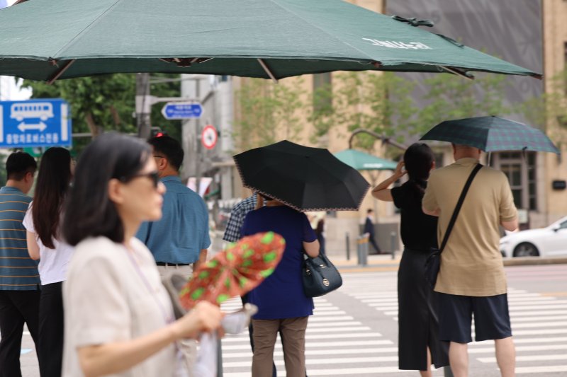 서울지역에 이틀째 폭염주의보가 지속 중인 지난 1일 서울 종로구 광화문광장 인근에서 시민들이 더위를 피해 그늘에서 신호대기를 하고 있다. 뉴시스