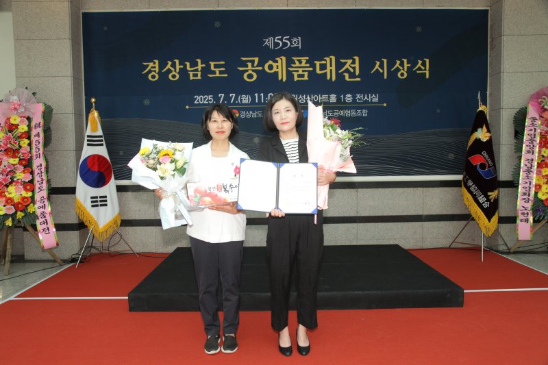 [창원=뉴시스]7일 오전 경남 창원 성산아트홀 전시관에서 제55회 경상남도 공예품대전 도자 분야에 '봄날의 햇살처럼 눈부신 날에'를 출품해 영예의 대상을 차지한 김해 문경유(오른쪽) 작가가 진필녀 경남도 문화산업과장으로부터 도지사 상장을 받은 후 기념촬영하고 있다.(사진=경남도 제공) 2025.07.07. photo@newsis.com