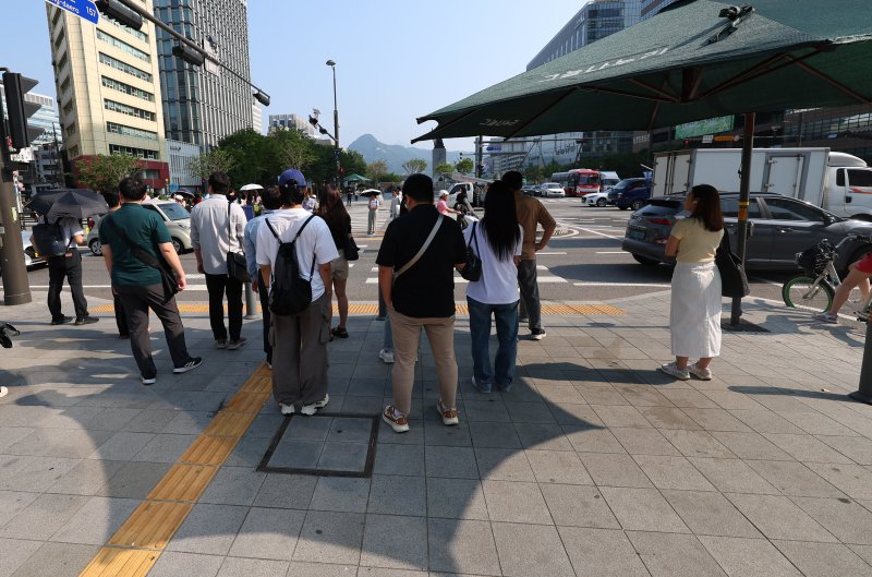 [서울=뉴시스] 최진석 기자 = 폭염이 이어지고 있는 8일 서울 세종대로사거리 인근에서 출근길 시민들이 그늘막 아래로 들어가 햇볕을 피하고 있다. 2025.07.08. myjs@newsis.com