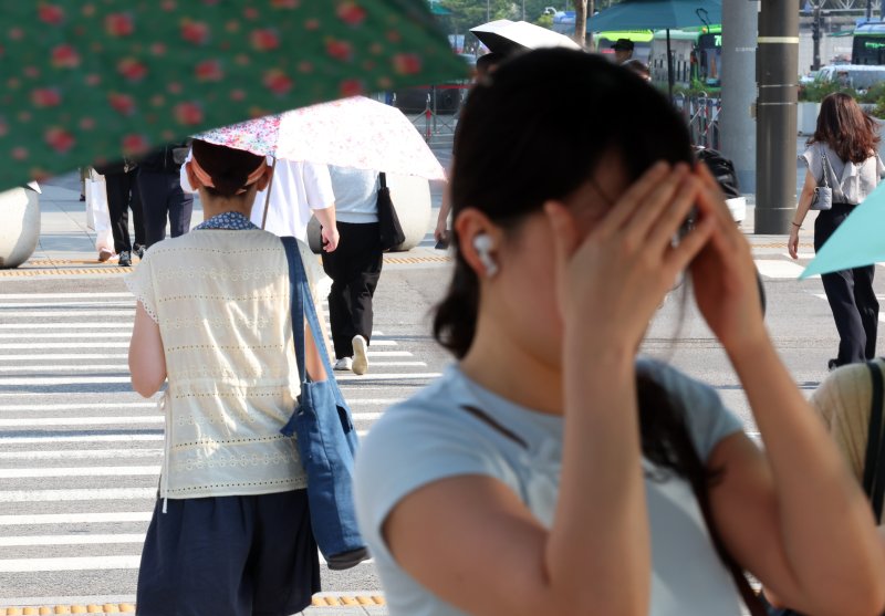 [서울=뉴시스] 최진석 기자 = 폭염이 이어지고 있는 8일 서울 세종대로사거리 인근에서 출근길 시민이 손으로 햇볕을 가리고 있다. 2025.07.08. myjs@newsis.com