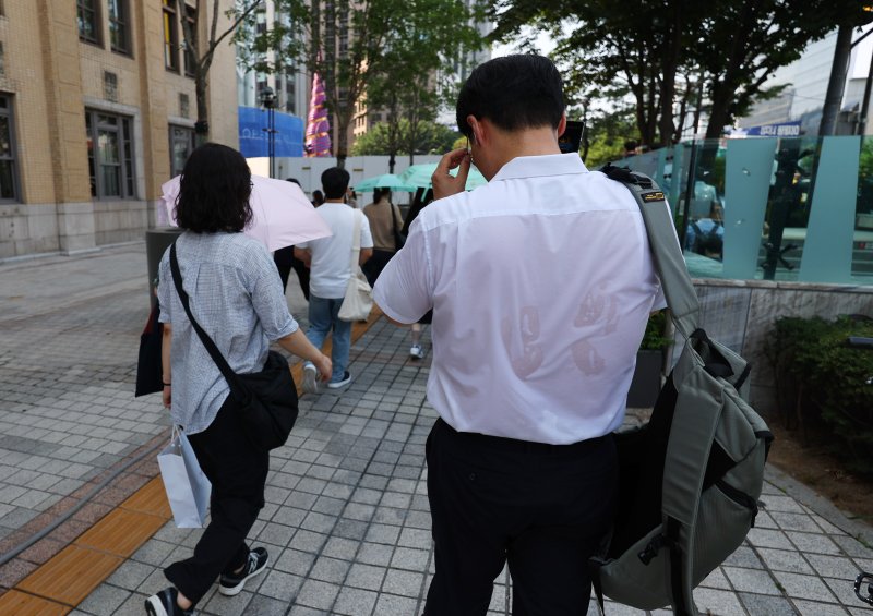 [서울=뉴시스] 최진석 기자 = 폭염이 이어지고 있는 8일 서울 세종대로사거리 인근에서 출근길 시민의 셔츠가 땀으로 젖어 있다. 2025.07.08. myjs@newsis.com