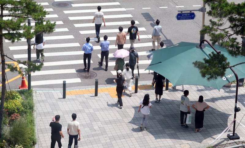 [서울=뉴시스] 최진석 기자 = 서울 지역에 폭염경보가 발효 중인 8일 서울 중구 을지로1가사거리에서 시민들이 햇볕을 피해 그늘막 아래서 신호를 기다리고 있다. 2025.07.08. myjs@newsis.com