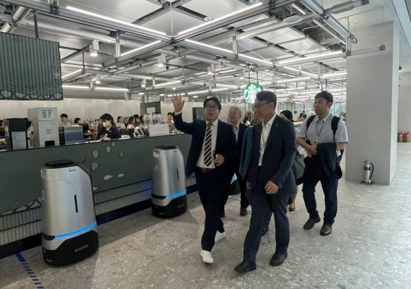 [성남=뉴시스]경남도 김명주(앞줄 오른쪽) 경제부지사가 8일 경기도 성남시 네이버 AI연구소를 방문해 간담회를 마친 후 세계 최초의 로봇 친화 건물 '네이버 1784' 내부를 둘러보고 있다. (사진=경남도 제공) 2025.07.08. photo@newsis.com