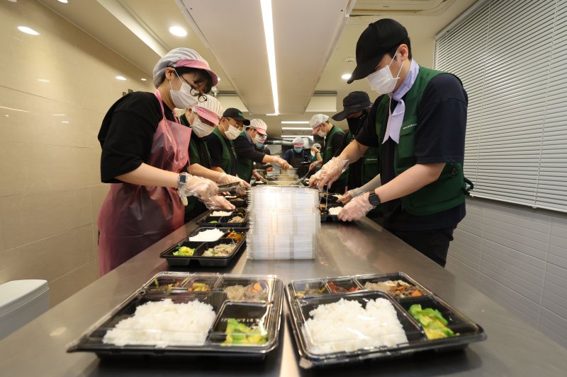 [서울=뉴시스] 권창회 기자 = 염영남 뉴시스 대표이사를 비롯한 직원들이 8일 서울 용산구 가톨릭사랑평화의집에서 도시락 배달 봉사를 하기 위해 음식을 포장하고 있다. 2025.07.08. kch0523@newsis.com