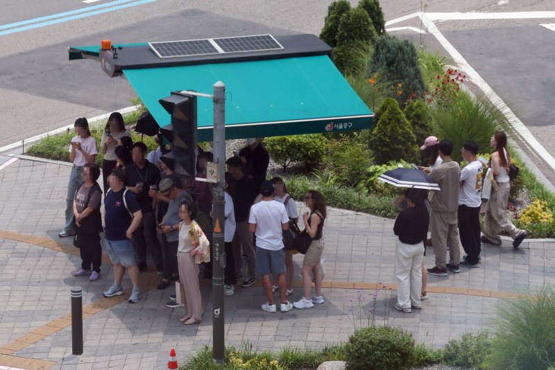 서울 지역에 폭염경보가 발효 중인 8일 서울 중구 을지로1가사거리에서 시민들이 햇볕을 피해 그늘막 아래서 신호를 기다리고 있다. 뉴시